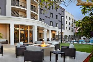 a courtyard with chairs and a fire pit in front of a building at Courtyard by Marriott Stuart in Stuart