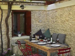 a wooden table with red chairs and a stone wall at Scalarea Estate Residences in Skalánion +28 photos