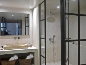 a bathroom with a shower and a sink and a mirror at Scalarea Estate Residences in Skalánion
