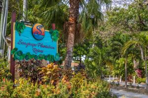 a sign for a swimming paradise park with palm trees at Seagrape Plantation Resort & Dive Center in West End
