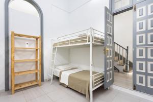 Wanderlust Hostel في سانتا كروث دي تينيريفه: غرفة نوم مع سرير بطابقين وسلم