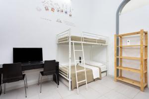 1 dormitorio con litera y escritorio con ordenador en Wanderlust Hostel en Santa Cruz de Tenerife