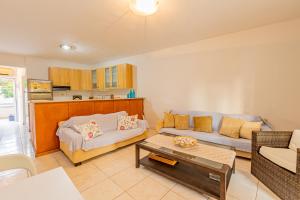 a living room with a couch and a table at Thalassa Apartments in Kallithea Halkidikis