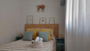 1 dormitorio con 1 cama con almohadas amarillas y azules en Villa la Candelaria en Sierra de los Padres