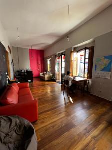 a living room with a red couch and a table at Hostel Matilda in Curitiba