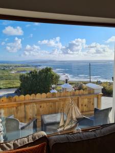 a view of the ocean from a patio with a model boat on a table at sea view apartment in Letterkenny