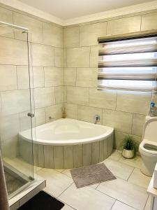 a bathroom with a bath tub and a toilet at Mjejane Debs guest house in Hectorspruit +134 photos