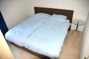 een bed met witte lakens en een tafel in een kamer bij The Hill in Domburg