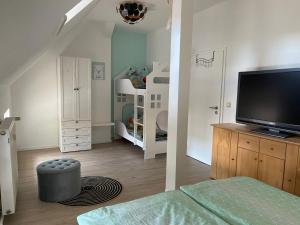 a room with a bedroom with a tv and bunk beds at Ferienwohnung Unter den Linden in Halbe