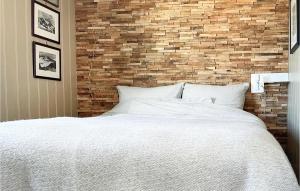 a bedroom with a white bed and a brick wall at Nice Home In Gol With Kitchen in Golsfjellet