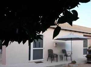 a patio with a table and an umbrella at Apartments dimitra in Kanallákion