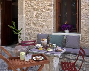 - une table et des chaises avec de la nourriture sur la terrasse dans l'établissement Scalarea Estate Residences, à Skalánion