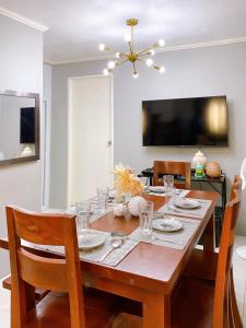 a dining room with a table with chairs and a television at The Doll House 1 in Orani