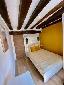 Habitación pequeña con cama con pared amarilla en Le Mimosa, en Rouen