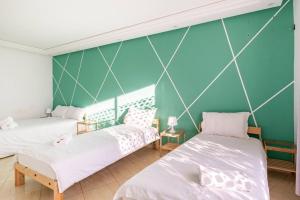 2 letti in una camera con parete verde di TT Holidays Hassan Tower 3Bedrooms a Rabat