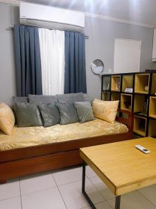 um sofá com almofadas na sala de estar em The Doll House 1 em Orani