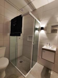 uma casa de banho com um chuveiro, um WC e um lavatório. em VILLA BILAC 10 - Studio próximo à Vila Germânica Bairro da Velha em Blumenau