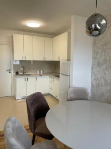 eine Küche mit einem weißen Tisch und Stühlen sowie einem weißen Tisch und Stühlen in der Unterkunft Apartments City View in Igalo