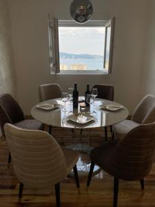 una mesa con copas de vino y botellas de vino. en Apartments City View, en Igalo