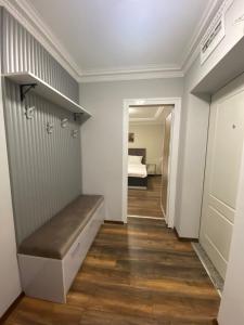 a hallway with a bench in a room with a bed at Апартамент в Сарафово in Burgas City