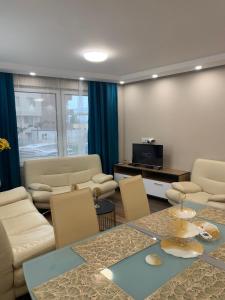 a living room with a couch and a table and chairs at Апартамент в Сарафово in Burgas City