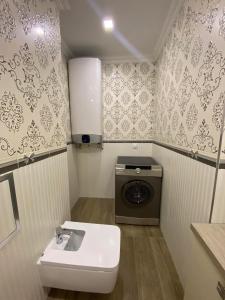 a bathroom with a sink and a washing machine at Апартамент в Сарафово in Burgas City