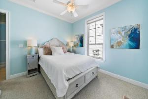 a blue bedroom with a bed and a ceiling fan at 30A Rise and Shine in Seagrove Beach +20 photos