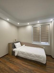 a bedroom with a large bed and a window at Апартамент в Сарафово in Burgas City