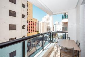d'un balcon avec une table et une vue sur la ville. dans l'établissement Flat Top - 100 M Da Praia De Pitangueiras 4083, à Guarujá