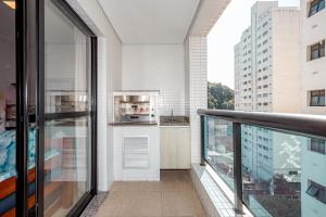 Cet appartement dispose d'un balcon offrant une vue sur un bâtiment. dans l'établissement Flat Top - 100 M Da Praia De Pitangueiras 4083, à Guarujá