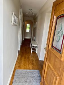 a hallway with a wooden door and a wooden floor at Carrick House, Mid-Ulster in Knockcloghrim