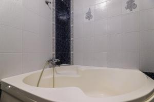a bathroom with a white tub and a toilet at Naukova Street Appartamento in Lviv