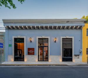 um edifício azul com três portas numa rua em Casona Las Tres Marías - Hotel Only adults em Mérida
