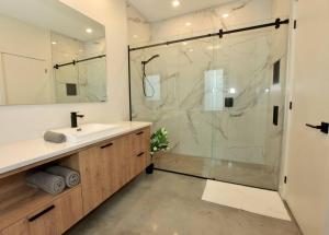 a bathroom with a shower and a sink and a mirror at L'Auguste - Luxe et confort in Petite-Rivière-Saint-François +25 photos