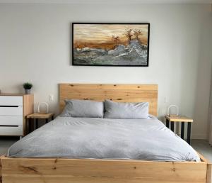 a bedroom with a bed and a painting on the wall at L'Auguste - Luxe et confort in Petite-Rivière-Saint-François