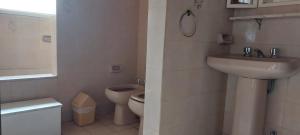 y baño con lavabo y aseo. en Villa la Candelaria en Sierra de los Padres