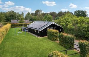 Reersø的住宿－Beautiful Home In Grlev With Kitchen，一座位于庭院的黑色房子,屋顶是太阳能