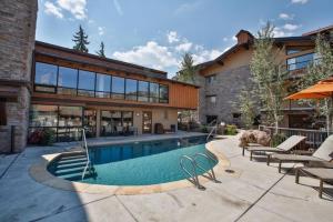 een huis met een zwembad naast een gebouw bij Snowmass Village 2 Bedroom Premier Condo At Crestwood in Aspen