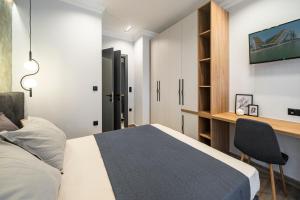a bedroom with a bed and a desk at ARES penthouse in Thessaloniki