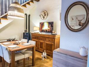 a dining room with a table and a dog sitting on the floor at Acogedor apartamento entre montañas in Sant Corneli de Cercs 