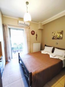 um quarto com uma cama grande e uma varanda em Maria's Rose Garden em Lefkada