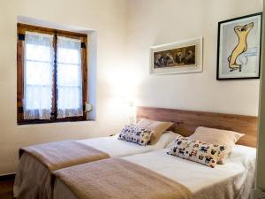 1 dormitorio con 2 camas y ventana en Acogedor apartamento entre montañas, en Sant Corneli de Cercs 