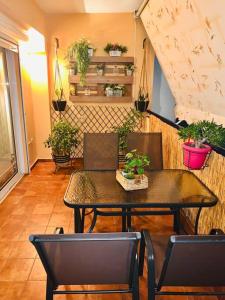 comedor con mesa, sillas y plantas en Cozy and relax apartment, en Kalamata