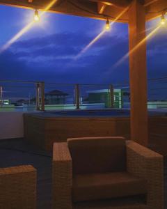 Un balcón con una silla y vistas al océano. en 3bed Apartment con Terraza y Picsina privada en Santo Domingo