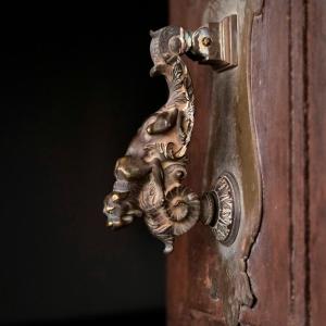un ancien bouton de porte en bronze sur une porte en bois dans l'établissement CASA RURAL PALACIO CONDE DE ALDANA con piscina entre encinares y dehesas, à Terradillos