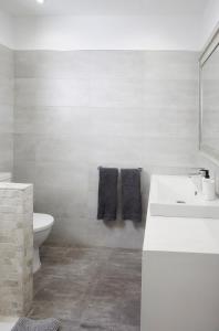 a white bathroom with a sink and a toilet at City Center Penthouse with Solarium 2 minutes from the Beach in Fuengirola