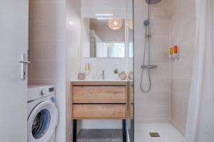 een badkamer met een douche en een wasmachine bij La Bouverie in Romans-sur-Isère