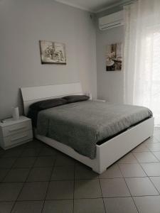 una camera bianca con un letto e una finestra di Appartamento Conte Verde a Vercelli