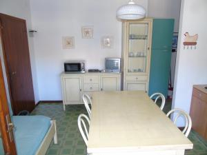 リニャーノ・サッビアドーロにあるCondominio Ginestraのキッチン(テーブル、椅子、冷蔵庫付)