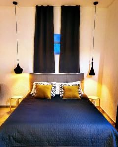 - une chambre avec un lit bleu et 2 oreillers jaunes dans l'établissement studio Square Funtana, à Funtana
